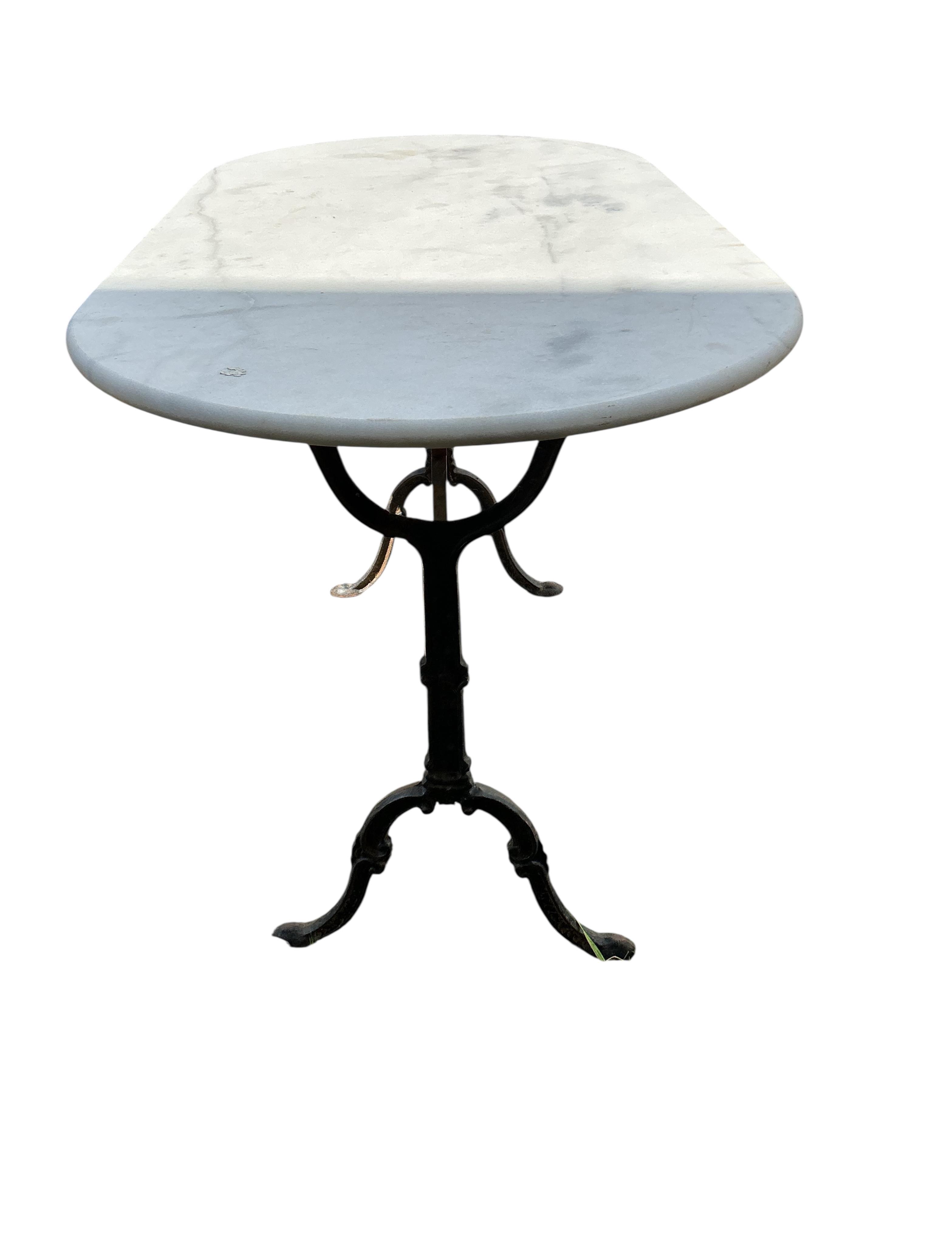 An oval reconstituted marble and cast iron garden table, width 120cm, depth 60cm, height 71cm